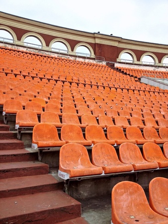 Seating rows in a stadium with weathered chairsの素材