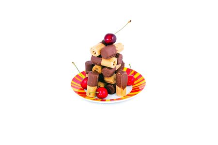 sweet chocolate puffs bright  plate and cherries isolated on whiteの写真素材