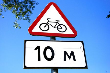 road cycle sign with informational plate and blue skyの写真素材