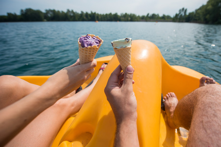 A couple of resting on a pedal boat on the lake. legs of men and women standing on the pedals of the boat.の写真素材