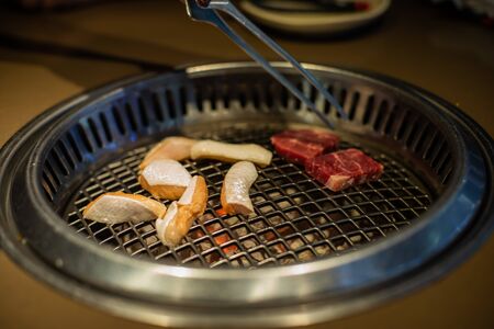 Fresh meat. Grilling meat in a Korean restaurant. Traditional Korean foodの写真素材