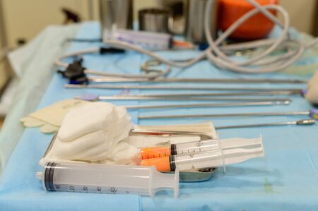 Plastic surgery to remove excess fat. Pumping fat into a jar during liposuction. Surgical instruments for liposuction in the operating roomの写真素材