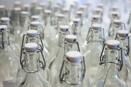 A closeup of the neck of a bottle. Group of empty bottles with plastic caps in a store on the counter.の写真素材