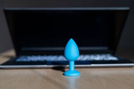 Blue latex anal plug the laptop on the table. The concept of virtual sex on the Internet. Anus...