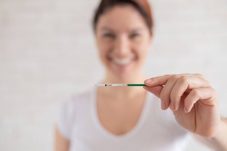 Happy woman shows a negative pregnancy test. The concept of female fertility. Human chorionic...