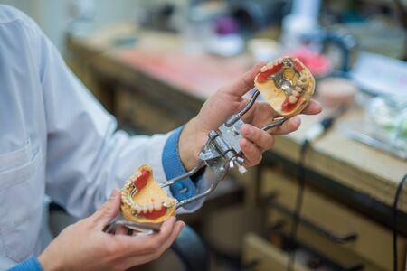 A dental technician makes partial dentures. The production of false teeth or dental bridges....