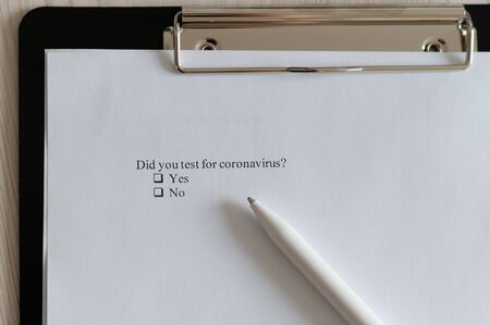 Coronavirus test questionnaire and pen on the table. Checklist for questions about covid-19.