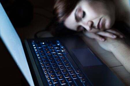 The exhausted employee worked overtime and fell asleep at his desk. Deadline Work at night with a...