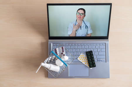 Video conference with a doctor on a laptop and tablet in a small shopping basket. Online pharmacy....