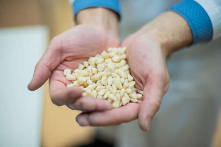 A dental technician is holding a bunch of dental implants. Close-up of male dentist hands with dentures.の写真素材