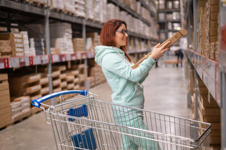 Novosibirsk, Russia - 02/26/2020: Beautiful young red-haired woman shopping at Ikea. Portrait of a...