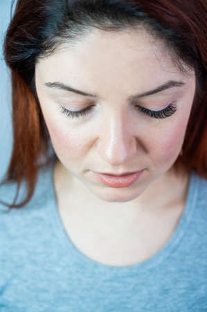 Caucasian woman with extended eyelashes in one eye for comparison
