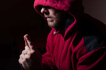 Suspicious bearded man in a hood in the darkの写真素材
