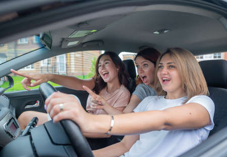 The amazed girlfriends travel in the car