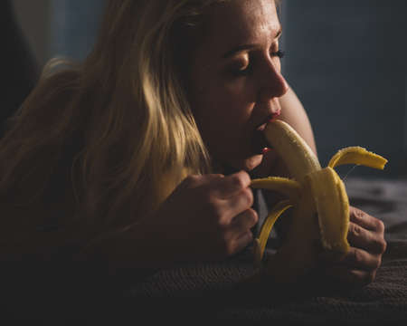 The blonde imitates oral sex and sucks a bananaの写真素材