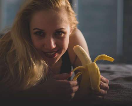 The blonde imitates oral sex and sucks a bananaの写真素材