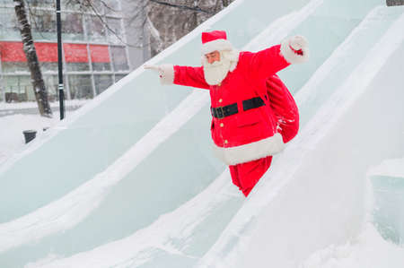 Santa Claus is rolling down the ice slideの写真素材