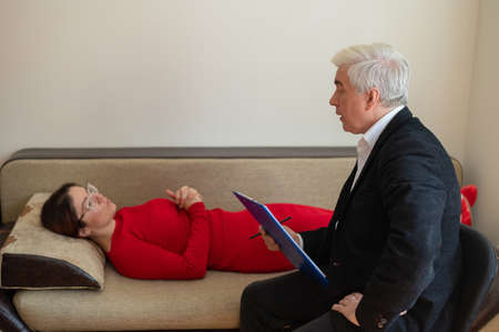A woman lies on a couch during a psychotherapy session