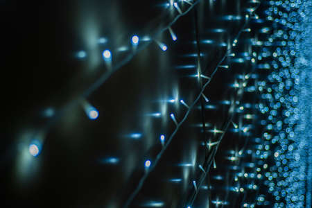 Fairy lights background - close up of blue and white garland lights with bokeh effectの写真素材