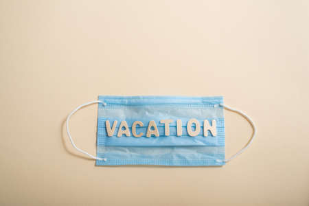 The inscription vacation on a medical mask on a light backgroundの写真素材