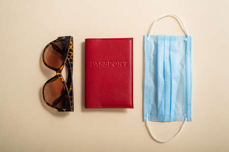 Sunglasses passport cover and medical mask top view. Vacation concept during the coronavirus epidemicの写真素材
