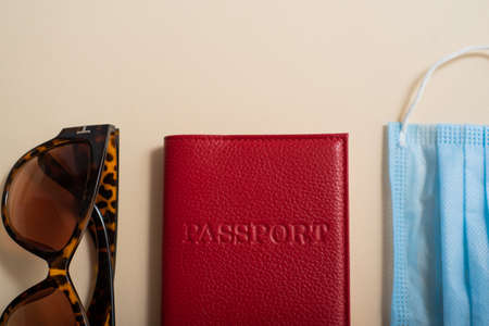 Sunglasses passport cover and medical mask top view. Vacation concept during the coronavirus epidemicの写真素材