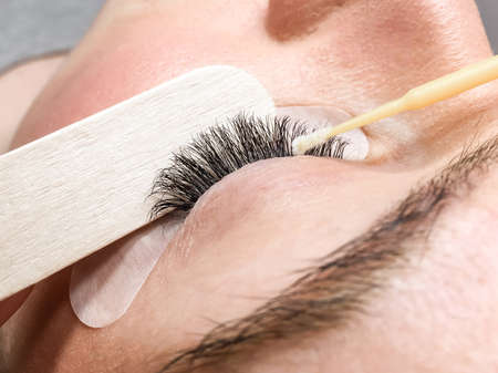 Close-up of the eyelash extension removal procedure. Portrait of a woman in a beauty salon