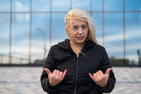 Emotional deaf and dumb woman talking sign language outdoors.