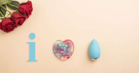 Rose heart and clitoral vibrator on a beige background. Flat lay