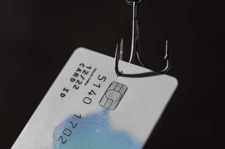 Close-up of a credit card on a fishing hookの写真素材