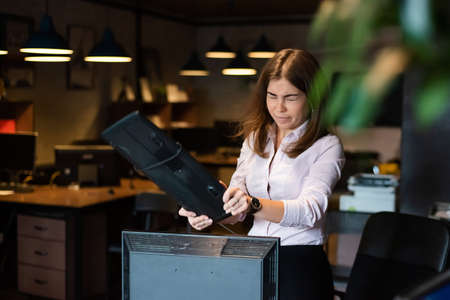 Nervous breakdown at work. Business woman freaks out and breaks the computer in the officeの写真素材