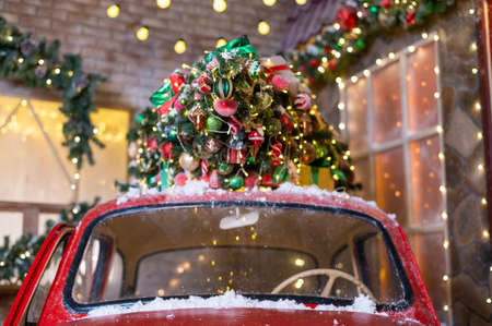 Christmas tree on a red classic car outdoors. Decorated santa claus carの写真素材