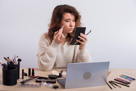 Online training for make-up. A woman teacher explains the makeup application scheme on the airの写真素材