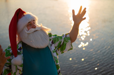 Santa Claus walks along the beach by the sea. Santa is on vacation in a hot country.の写真素材