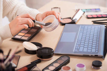A faceless woman watches online training from a professional makeup artist on a laptop. Distance learningの写真素材
