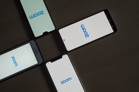 November 8, 2020 Russia, Novosibirsk: Smartphones with zoom logo on the screen. Application for online communicationのeditorial素材