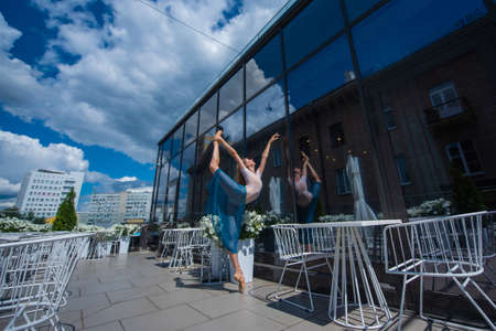 A beautiful ballerina is dancing outdoors on a warm summer day. Young woman in pointe shoes.の写真素材