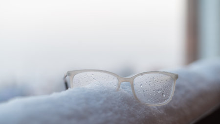 Womens glasses with white frames on the snowの写真素材