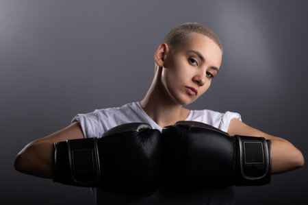 Young woman with short hair in boxing gloves on a white backgroundの写真素材