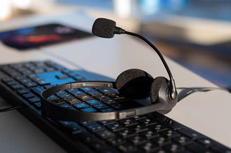 Headset with microphone on the computer keyboard. Call center operators workplace