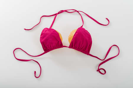 Pumpkin bra on a white background. Two pumpkins in a bikini. Copy space