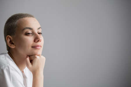 Portrait of pensive young woman with short hair on white background. Copy spaceの写真素材