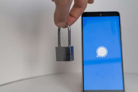 Mobile phone with messenger logo signal and lock on white background.のeditorial素材