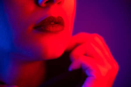 Close-up portrait of beautiful young woman with short hair in neon light. Girl with sensual lips in ultraviolet light.の写真素材