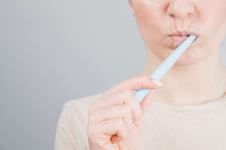 Close-up portrait of caucasian woman brushing her teeth. The girl performs the morning oral hygiene procedureの写真素材