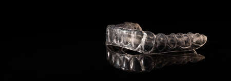 Removable plastic retainers for bite correction on a black background. Empty spaseの写真素材