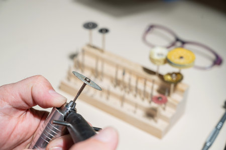 An optician technician polishes the frame of glasses. A professional optician fixes glasses.の写真素材