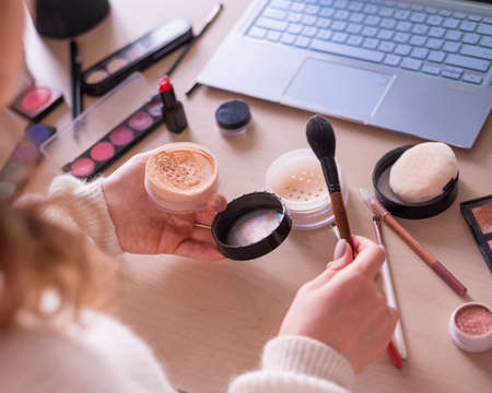 A faceless woman watches online training from a professional makeup artist on a laptop. Distance learningの写真素材