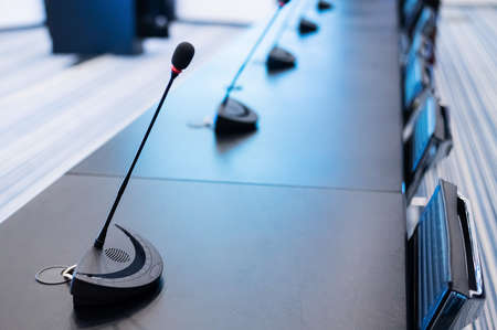 Close-up of microphones in an empty meeting room at a press conference.の写真素材