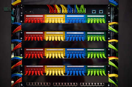 Multi-colored rows of network cables are connected to the systemの写真素材